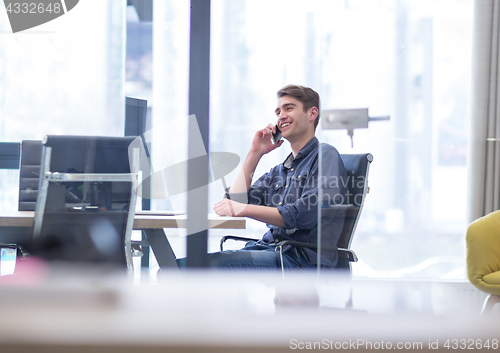 Image of Young casual businessman using smartphone