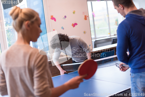 Image of startup business team playing ping pong tennis