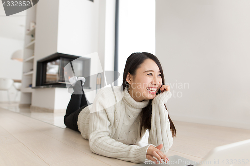 Image of young Asian woman using laptop on the floor