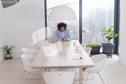 Image of Young casual businessman using smartphone