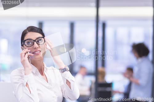 Image of Elegant Woman Using Mobile Phone in startup office building