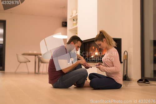 Image of Young Couple using digital tablet on cold winter night