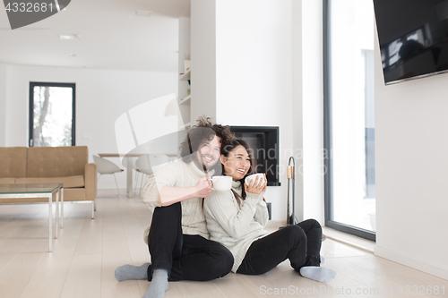 Image of happy multiethnic couple  in front of fireplace