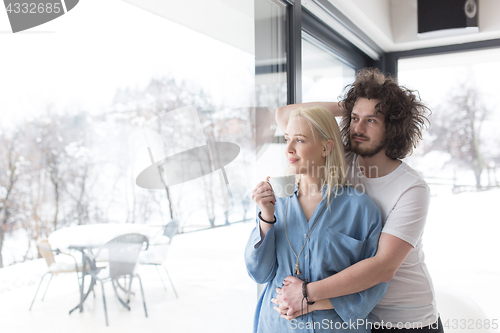 Image of young couple enjoying morning coffee by the window