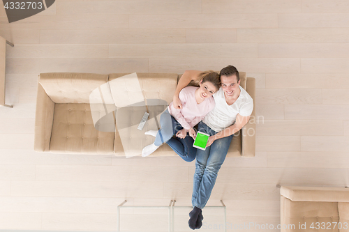 Image of young couple in living room using tablet top view