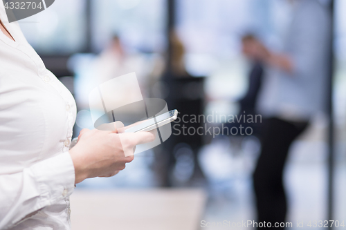 Image of Elegant Woman Using Mobile Phone in startup office building