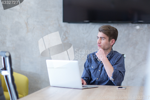 Image of businessman working using a laptop in startup office