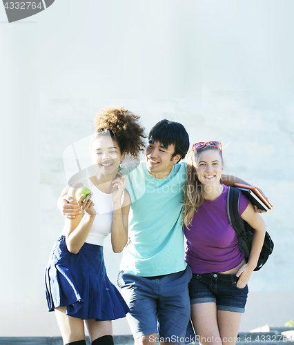 Image of cute group of teenages at the building of university with books huggings, back to school