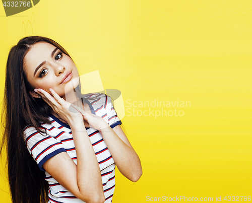 Image of young pretty teenage woman happy smiling posing on yellow backgr