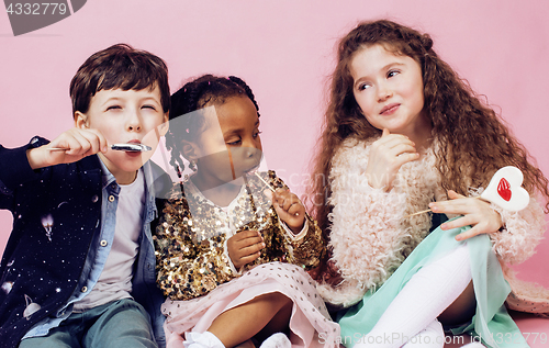 Image of lifestyle people concept: diverse nation children playing together, caucasian boy with african little girl holding candy happy smiling