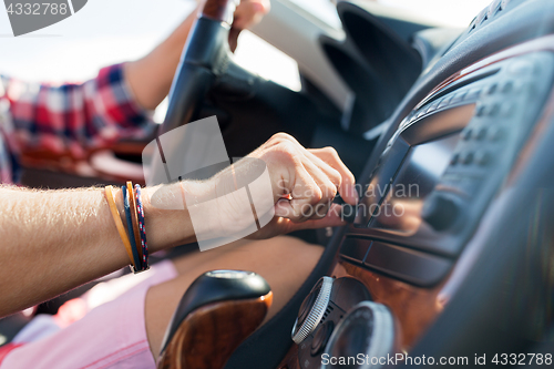 Image of man driving car and turning switch on dashboard