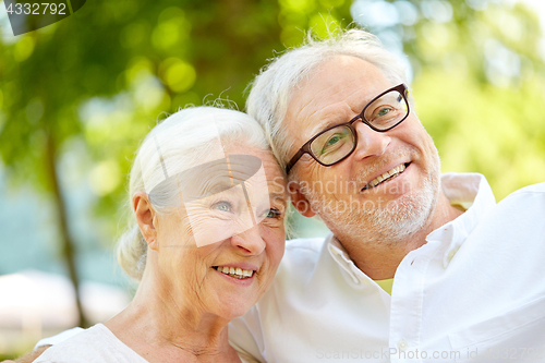 Image of happy senior couple taking selfie at summer park