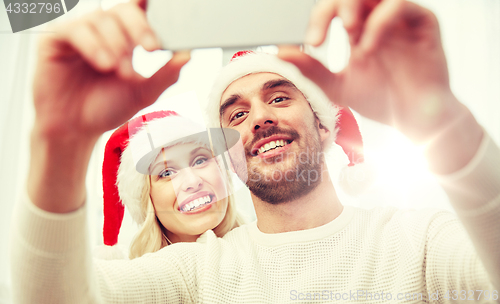Image of couple taking selfie with smartphone at christmas