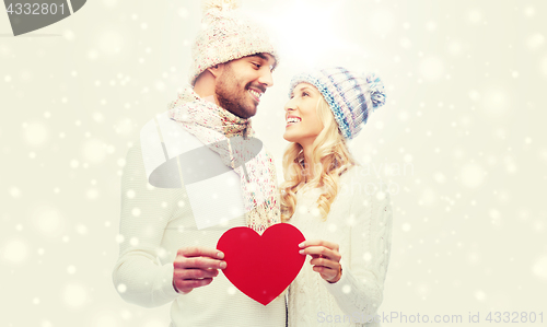 Image of smiling couple in winter clothes with red heart