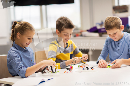 Image of happy children building robots at robotics school