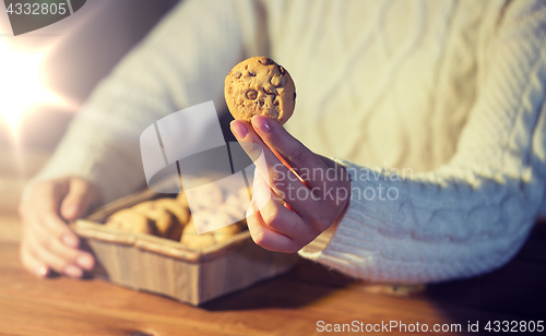 Image of close up of woman with oat cookies at home