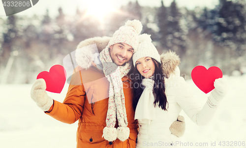 Image of happy couple with red hearts over winter landscape