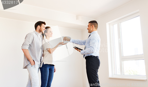 Image of realtor giving keys from new home to happy couple