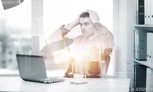 Image of stressing businessman with laptop at office