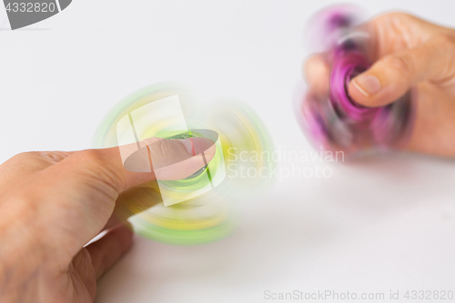 Image of close up of hands playing with fidget spinners