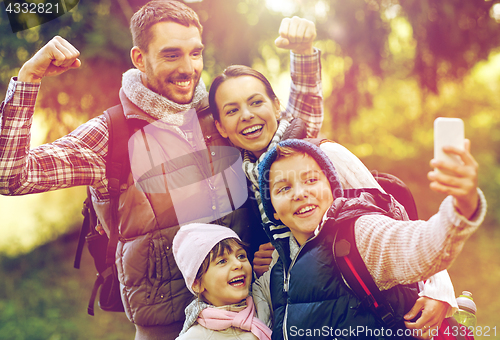 Image of family taking selfie with smartphone outdoors