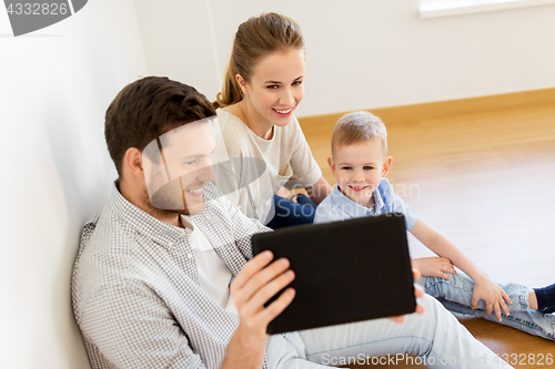 Image of happy family with tablet pc moving to new home