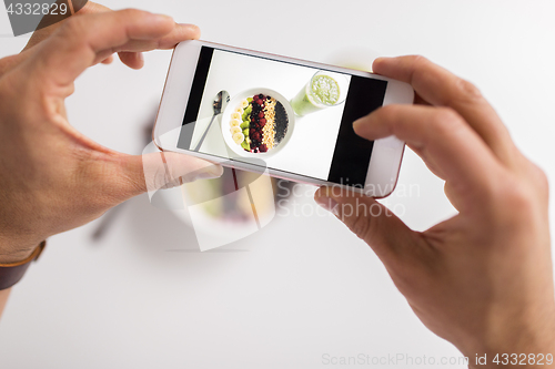 Image of man photographing healthy breakfast by smartphone