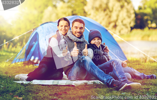 Image of happy family with tent at camp site
