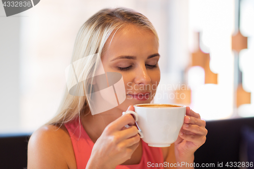 Image of close up of woman drinking coffee at restaurant