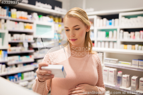 Image of happy pregnant woman with medication at pharmacy