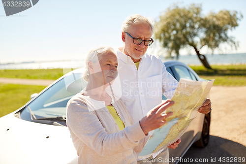Image of senior couple at car looking for location on map