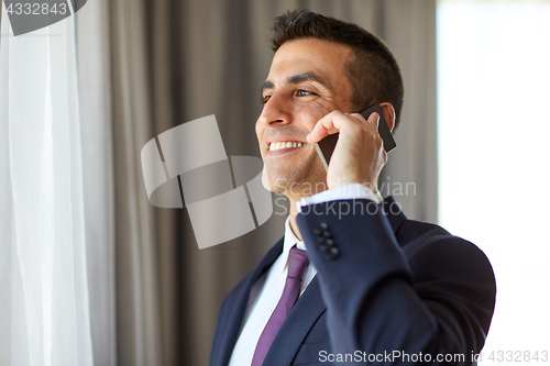 Image of businessman calling on smartphone at hotel room