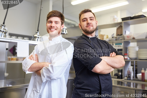 Image of happy smiling chef and cook at restaurant kitchen