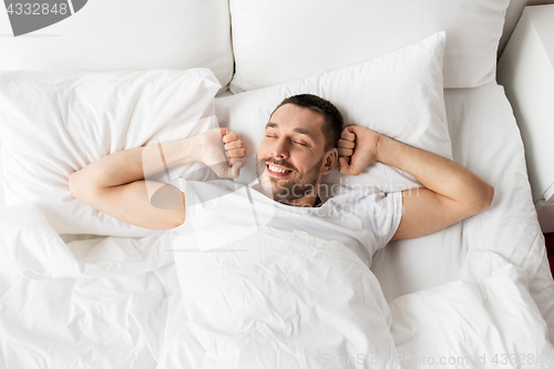 Image of man lying in bed at home