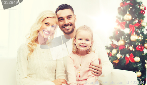 Image of happy family at home with christmas tree