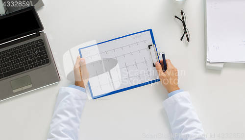 Image of doctor hands with cardiogram and laptop at clinic