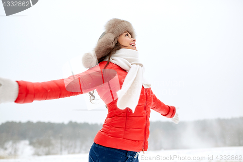 Image of happy woman in winter fur hat outdoors