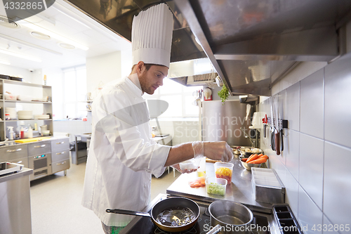 Image of happy male chef cooking food at restaurant kitchen