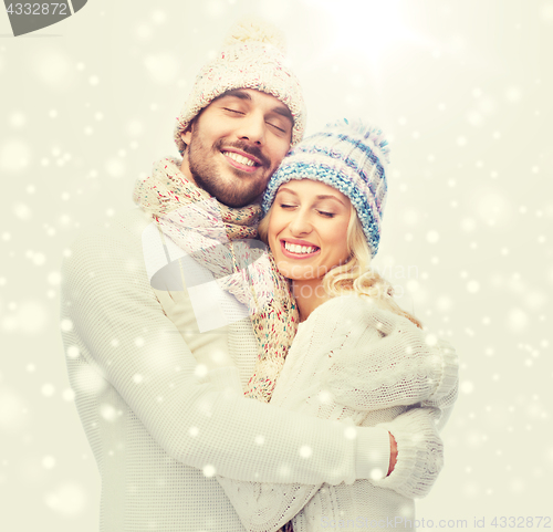 Image of smiling couple in winter clothes hugging