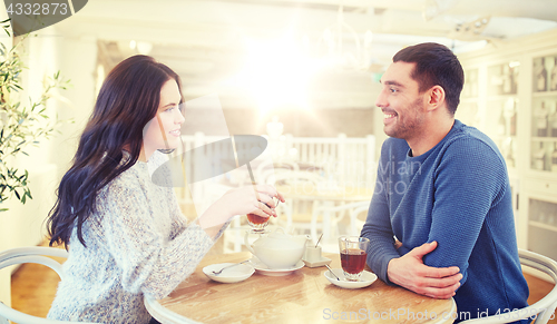 Image of happy couple drinking tea at cafe