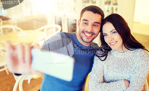 Image of couple taking smartphone selfie at cafe restaurant
