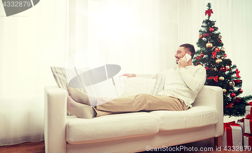 Image of man calling on smartphone at home for christmas