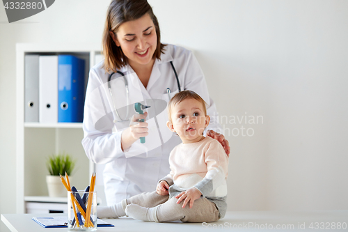 Image of doctor with baby and otoscope at clinic