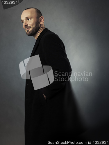 Image of bearded man in a black coat
