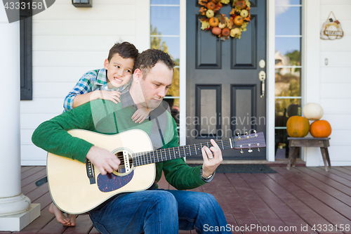 Image of Young Mixed Race Chinese and Caucasian Son Singing Songs and Pla