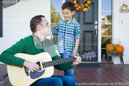Image of Young Mixed Race Chinese and Caucasian Son Singing Songs and Pla