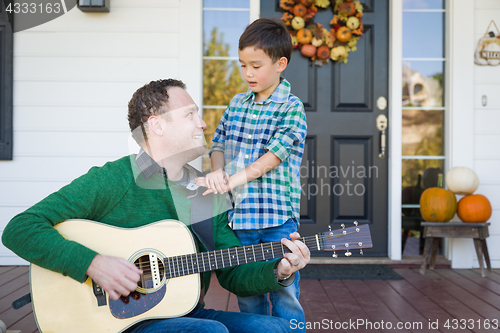 Image of Young Mixed Race Chinese and Caucasian Son Singing Songs and Pla