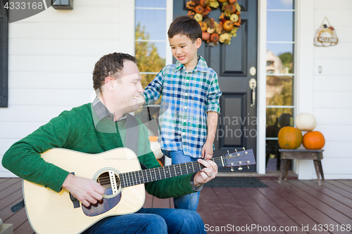 Image of Young Mixed Race Chinese and Caucasian Son Singing Songs and Pla