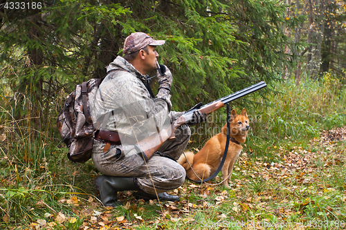 Image of hunter with a grouse call and shotgun