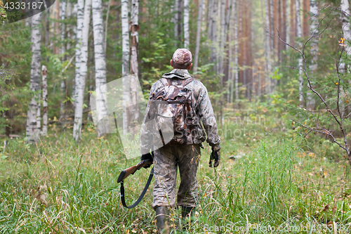 Image of hunter with gun in the forest
